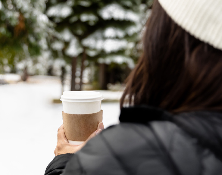 A guest enjoying hot chocolate in the snow at Tenaya at Yosemite